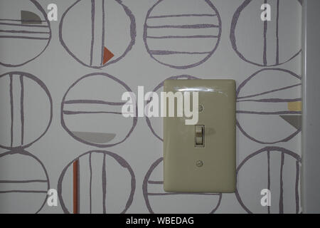 Electrical light switch on wall paper designed with modern art Stock Photo