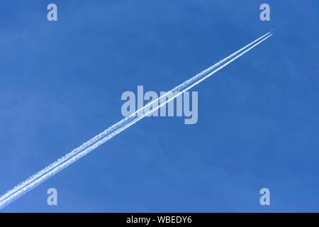Airplane with contrails in the blue sky, Bavaria, Germany Stock Photo