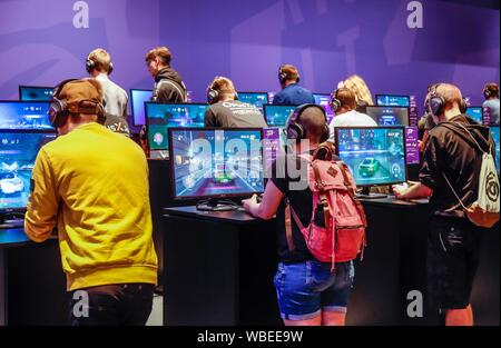 Young visitors at Need for Speed car racing game in front of screens, fair for computer and video games Gamescom, Cologne, North Rhine-Westphalia Stock Photo