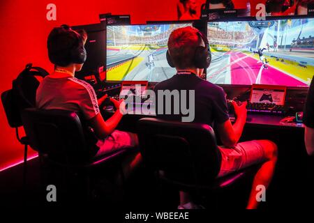 Boys playing computer games in front of screens, Fair for computer and video games Gamescom, Cologne, North Rhine-Westphalia, Germany Stock Photo
