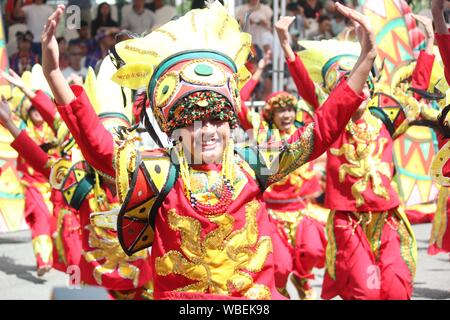 Davao City, Philippines-August 2014: Streetdancers in colorful costumes and headdresses at the Kadayawan festival. Kadayawan is celebrated August each Stock Photo