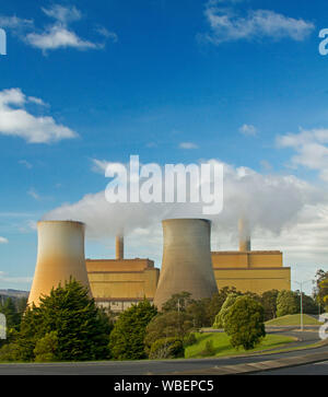 Yallourn North coal fired power station with smoke from tall towers rising into blue sky, Victoria Australia Stock Photo