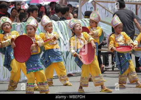 Davao City, Philippines-August 2014: Streetdancers at the Kadawayan festival parade in their colorful costumes and props. Kadayawan is celebrated Augu Stock Photo