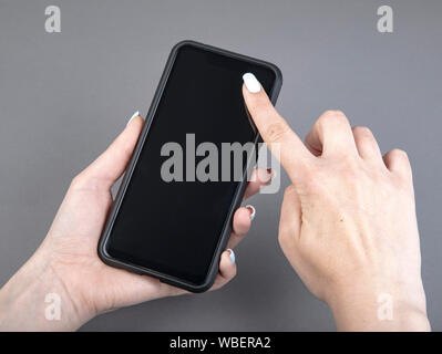 Womans hand holding black screen mobile phone Stock Photo