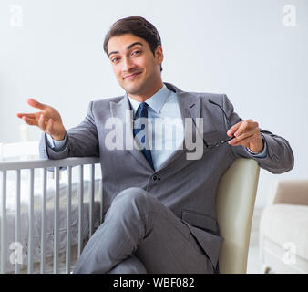 The young businessman trying to work from home caring after newborn Stock Photo