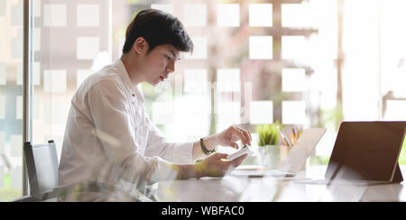 Young businessman working on his project with laptop computer in comfortable workplace Stock Photo