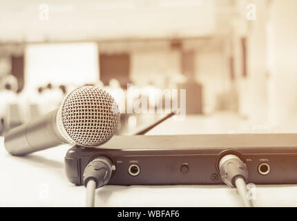 Close up old microphone wireless with box signal on the white table in business conference interior seminar meeting room and Background blur. Effects Stock Photo