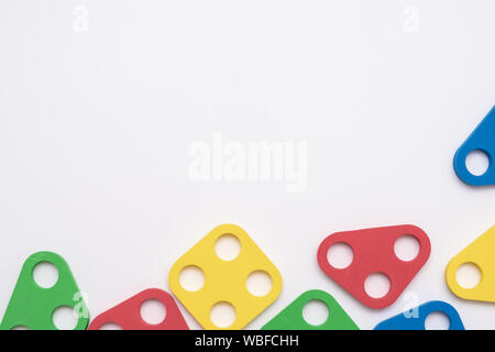 On a white background in a chaotic manner are large multi-colored childrens blocks-designer for the construction of houses and buildings of varying Stock Photo