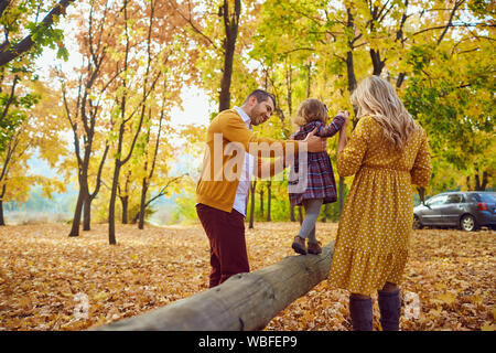 Family playing with their daughter on nature in the fall Stock Photo