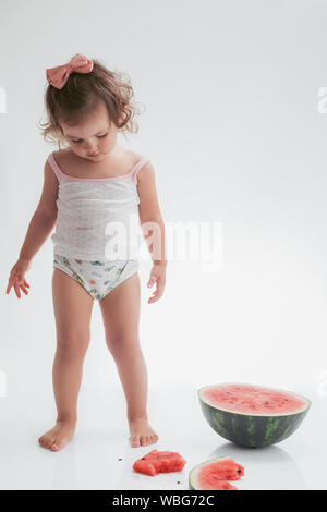 Baby girl eating watermelon slice isolated on white background. Stock Photo
