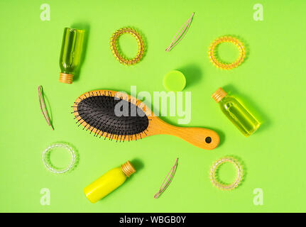Hair care products and styling items on green background. Flat lay style. Women beauty and beauty salon cosmetics concept. Stock Photo