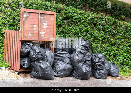 Big pile of black plastic garbage bags with trash stacked on the