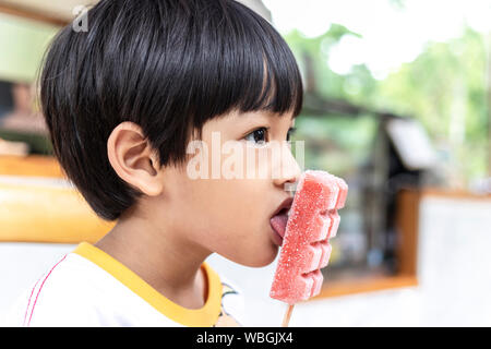 Asian cute little boy eating strawberry ice cream stick Stock Photo