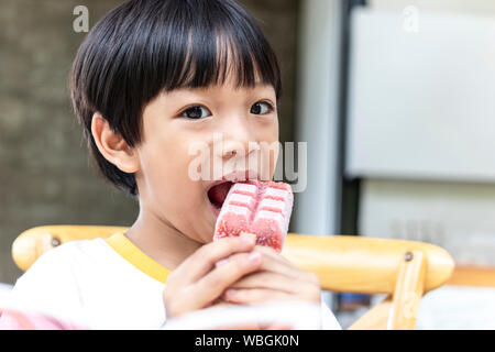 Asian cute little boy eating strawberry ice cream stick Stock Photo