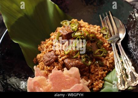 Nasi Goreng Rendang. Indonesian fried rice with Beef Rendang and its spice mix Stock Photo