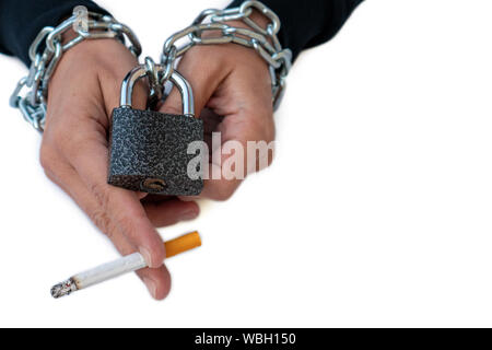 Woman's hands tied by chain and lock with cigarette on a white background.  Stop smoking concept, cigarettes, Addiction. unhealthy lifestyle concept  Stock Photo