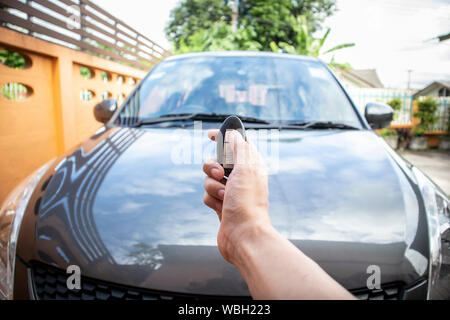 A man opening his car door with pushing button on control remote key. Stock Photo