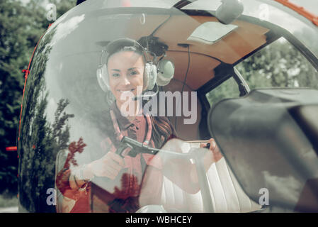 Dark-eyed woman feeling excited before flying the helicopter Stock Photo
