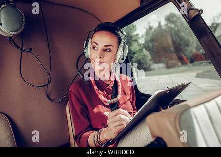 Businesswoman making some notes while flying in helicopter Stock Photo