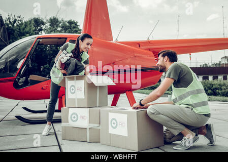 Volunteers packing clothes into boxes for sending them with helicopter Stock Photo