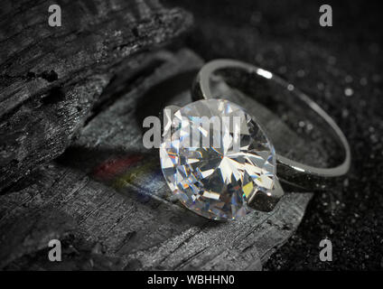 Jewelry ring with big diamond, on black coal texture background Stock Photo