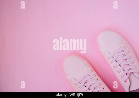 Pink women's sneakers on a pink background. Flat lay, top view, minimal background. Stock Photo
