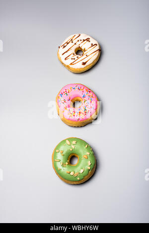 Three fresh sweet bonuts on studio background Stock Photo
