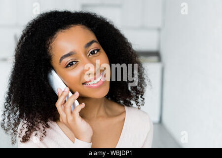portrait of african american woman speaking on smartphone and looking at camera Stock Photo