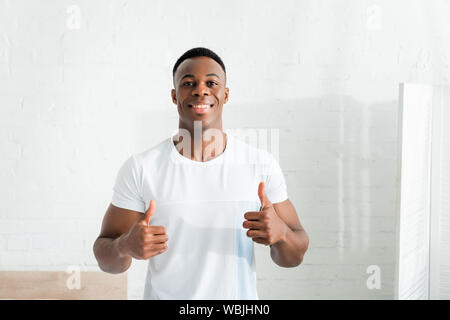 front view of happy african american man showing thumbs up, looking at camera Stock Photo