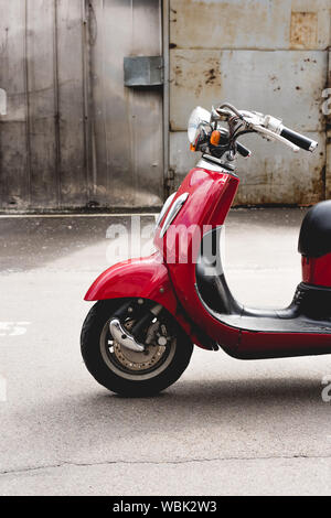 red scooter standing outside in sunlight place Stock Photo