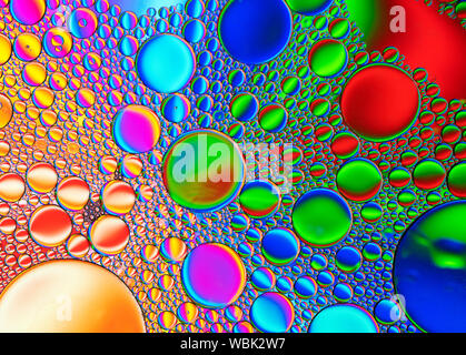 Multi-coloured bubble patterns formed by oil floating on water Stock Photo