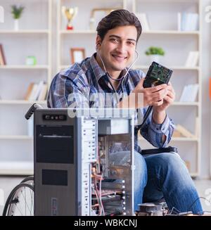 The computer repairman on wheelchair working Stock Photo