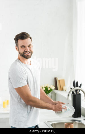 Man washing dishes at home stock photo. Image of handsome - 141020840