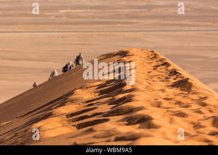 Blurred hiking group climbing up the ridge of Dune 45, Namib desert, Namibia Stock Photo