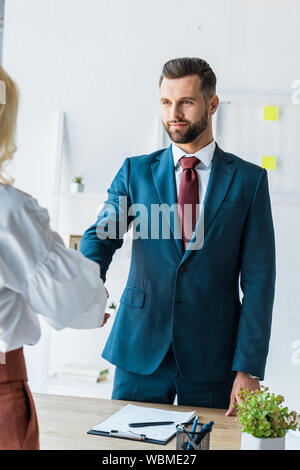 cropped view of employee and handsome recruiter shaking hands Stock Photo