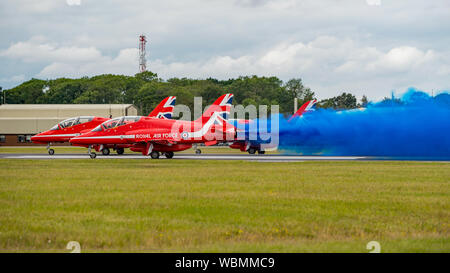 Aircraft of the RAF Red Arrows display team emit blue smoke on take off from RAF Fairford for their last UK display of the 2019 season on 21/7/19. Stock Photo