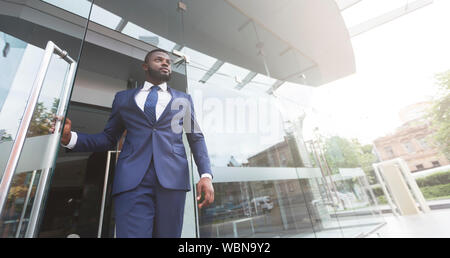 Young african job seeker leaving building after interview Stock Photo