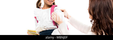 panoramic shot of mother touching backpack of happy daughter isolated on white Stock Photo