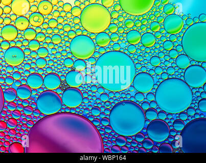 Multi-coloured bubble patterns formed by oil floating on water Stock Photo