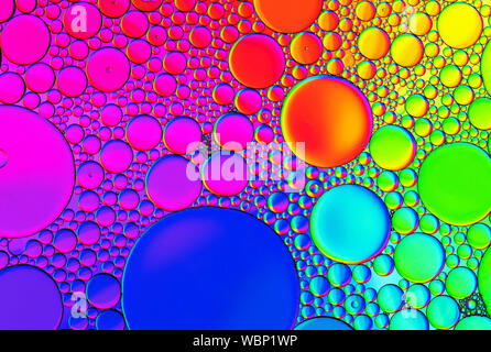 Multi-coloured bubble patterns formed by oil floating on water Stock Photo