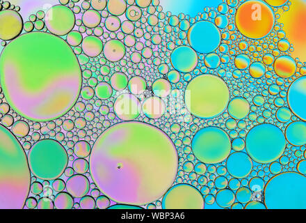 Multi-coloured bubble patterns formed by oil floating on water Stock Photo