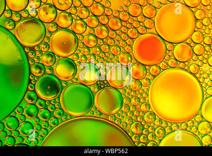 Multi-coloured bubble patterns formed by oil floating on water Stock Photo