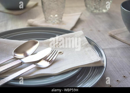 Close-up of summer table setting in rustic style with linen napkin and silverware. Stock Photo