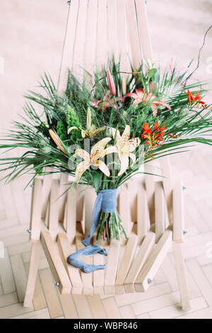 Beautiful tropical wedding bouquet on the chair. Stock Photo
