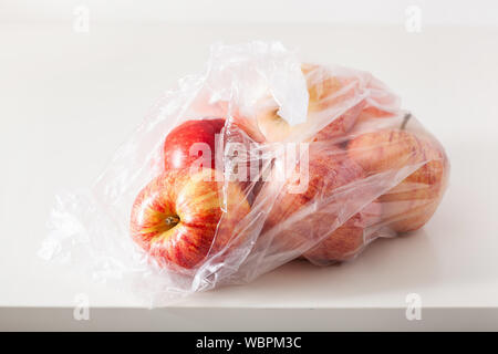single use plastic packaging issue. apples in plastic bag Stock Photo