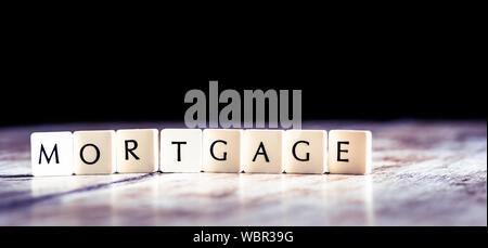 Mortgage word made of tiles on dark wooden background Stock Photo