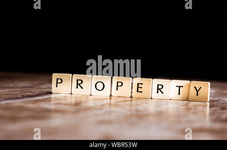 Property word made of tiles on dark wooden background Stock Photo