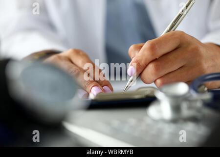 Arms of GP writing with silver pen document Stock Photo
