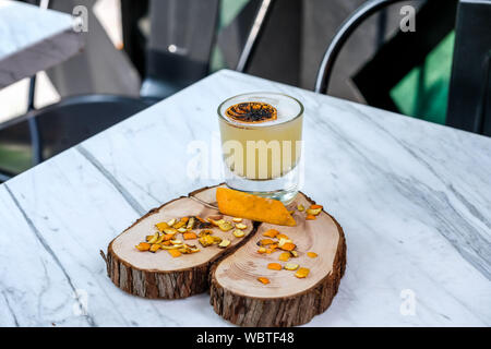 Whiskey cocktail smoked with orange smoke at the marble table Stock Photo
