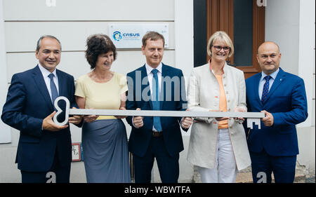27 August 2019, Saxony, Görlitz: Octavian Ursu (CDU, l-r), Lord Mayor of Görlitz, Eva-Maria Stange (SPD), Saxony's Minister of Science, Michael Kretschmer (CDU), Prime Minister of Saxony, Anja Karliczek (CDU), Federal Minister of Research, and Rafal Gronicz, Polish Mayor of Zgorzelec (Poland), hold a symbolic key in front of the first building of the new research centre CASUS (Center for Advanced Systems Understanding). The house at the historical sub-market has to be renovated first. Photo: Oliver Killig/dpa-Zentralbild/dpa Stock Photo